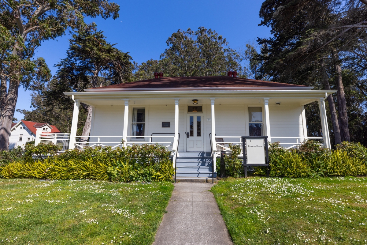 a white house with columns and a sidewalk