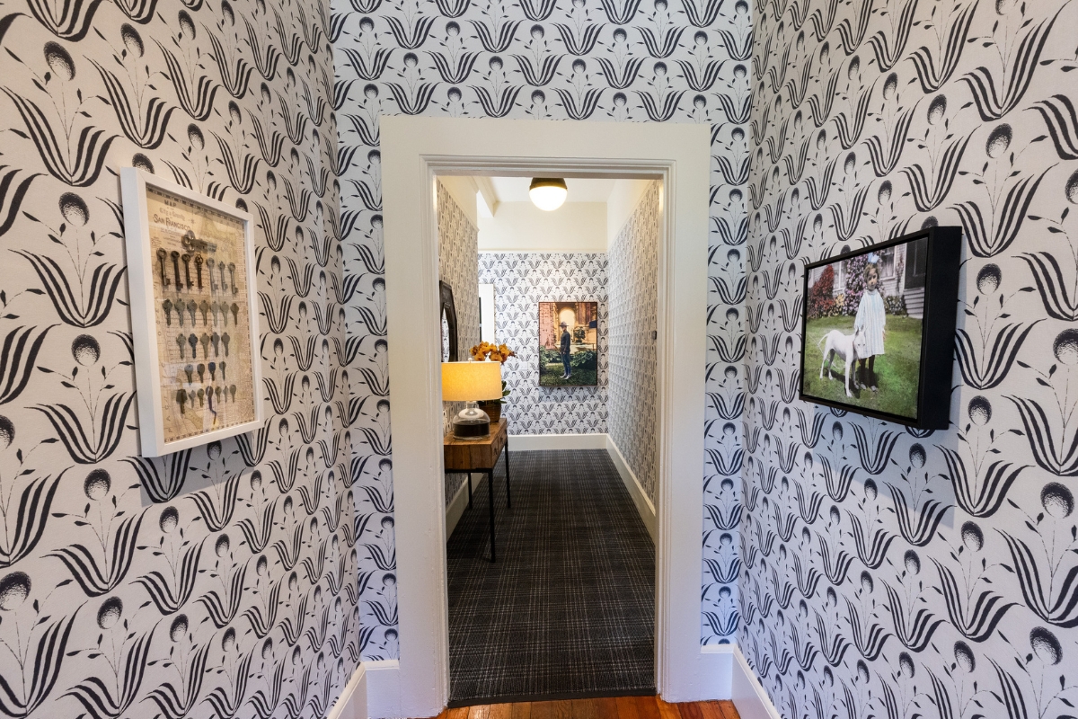 a hallway with a door open and a picture on the wall