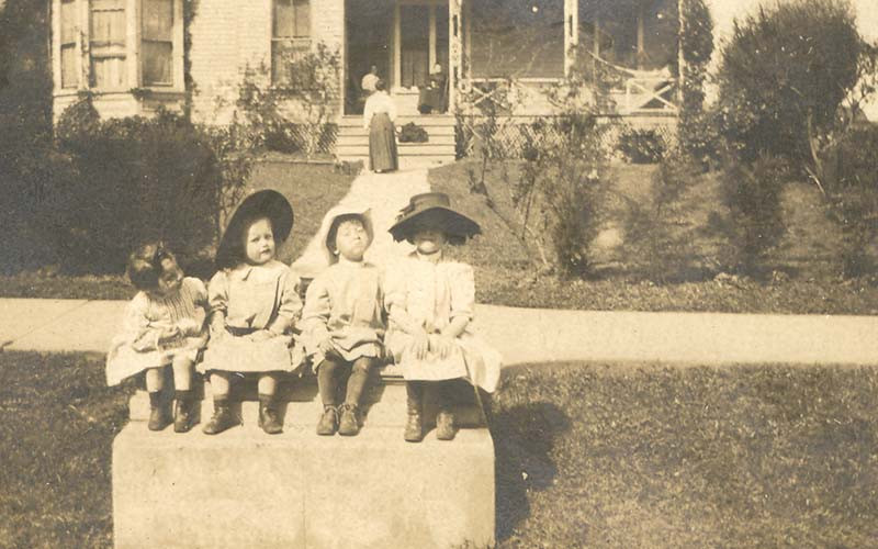 a group of children sitting on a ledge
