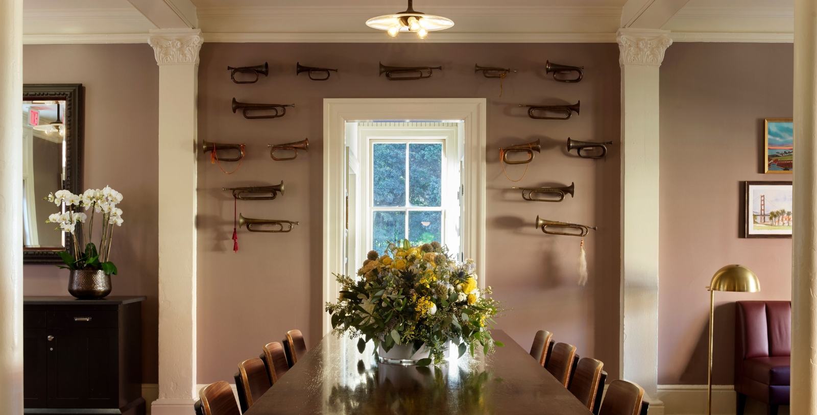 a table with flowers on it and a window with horns on the wall