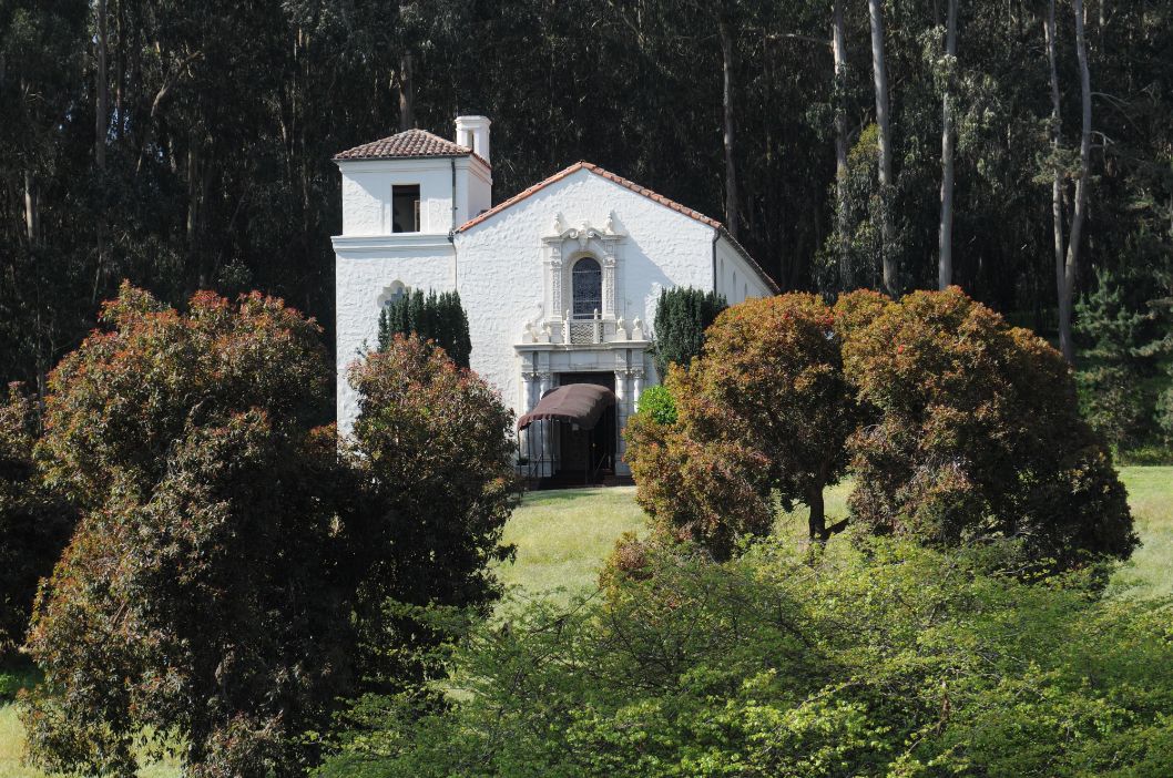 a white house with trees around it