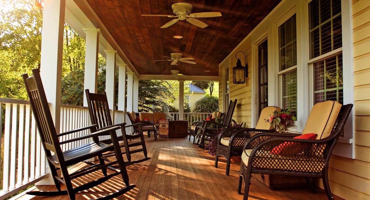 a porch with rocking chairs and a fan