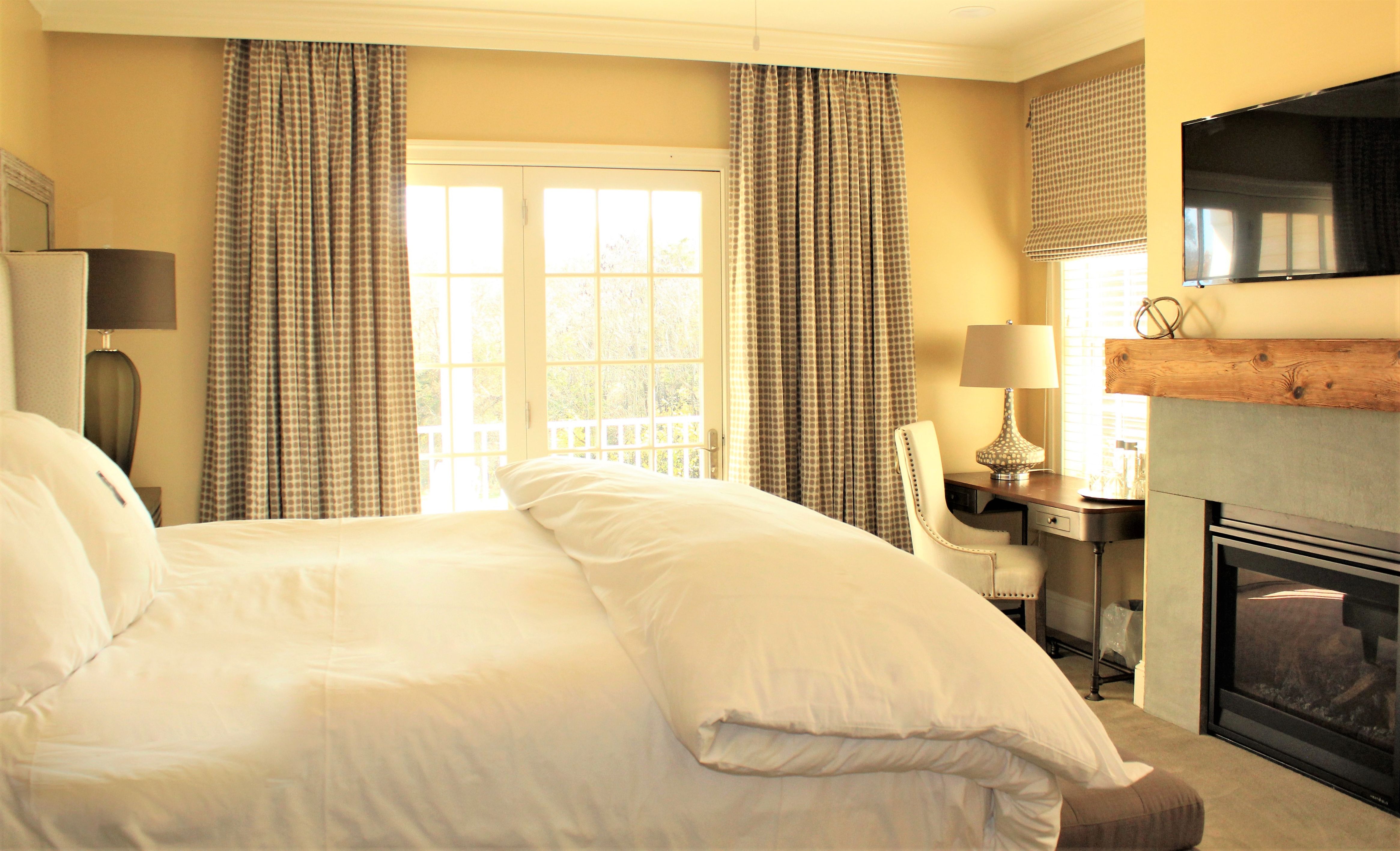 a bed in a room with a desk and curtains