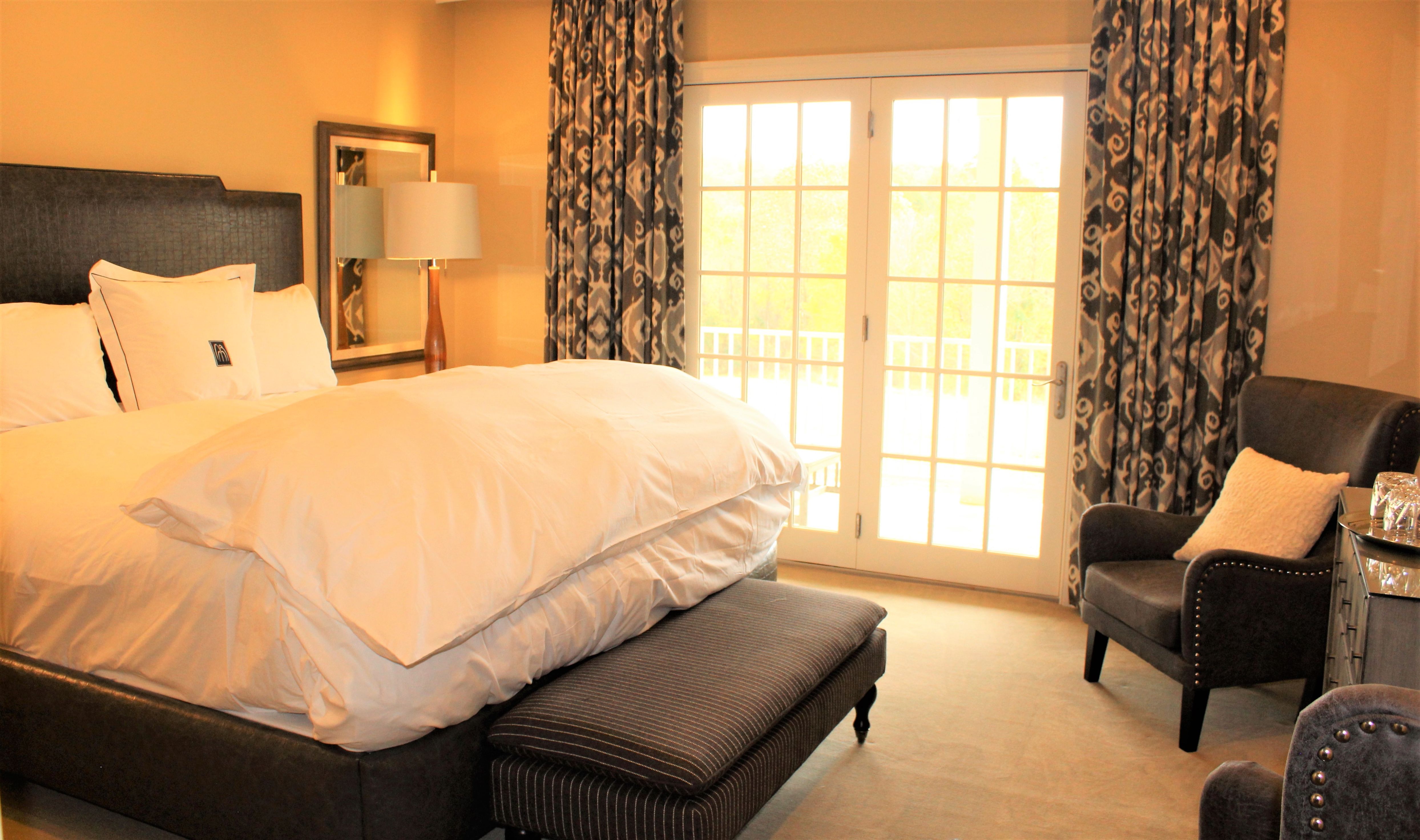 a bed in a room with a chair and a window