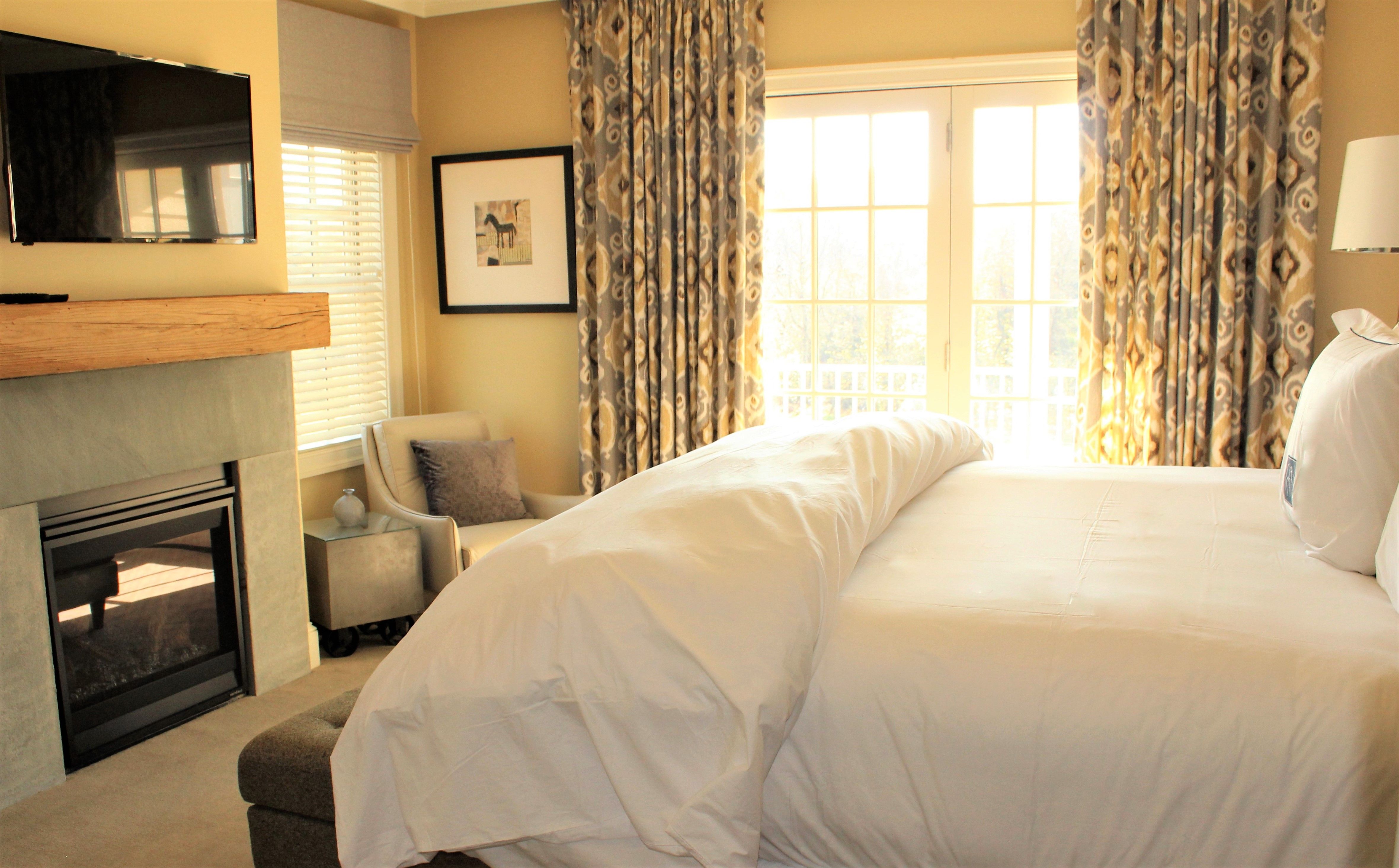 a bed in a room with a fireplace and a chair