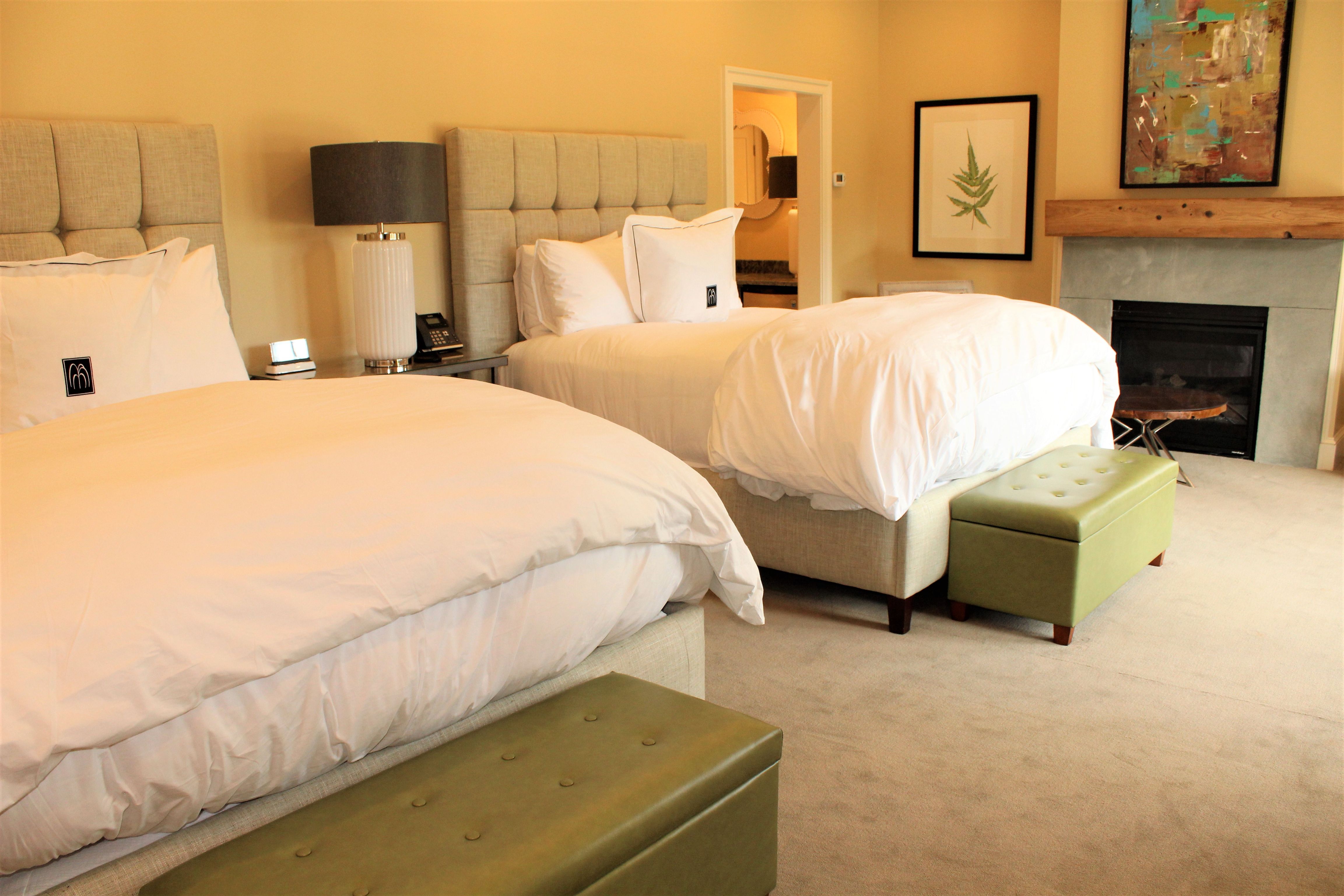 a room with two beds and a fireplace