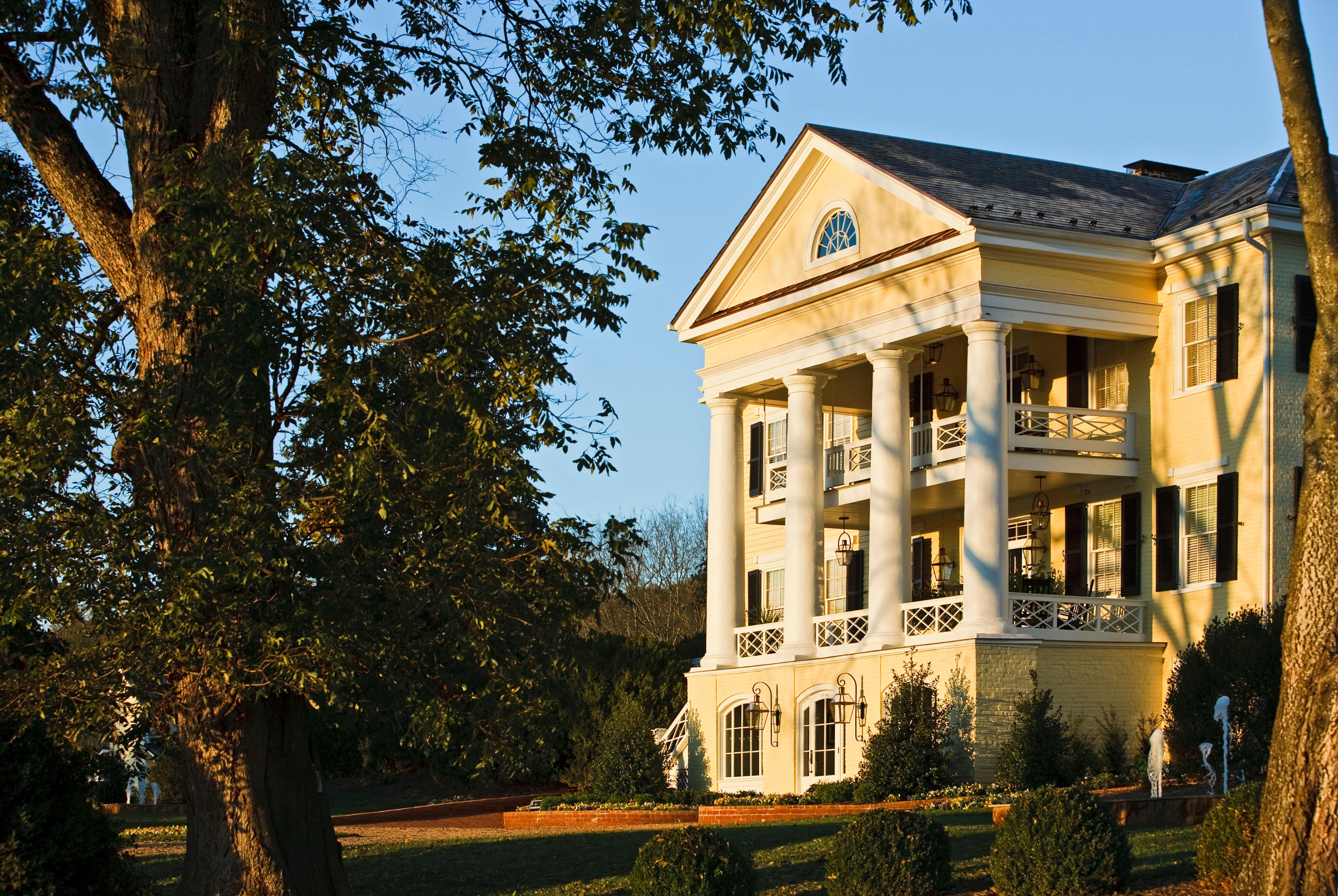 a large house with columns and a tree