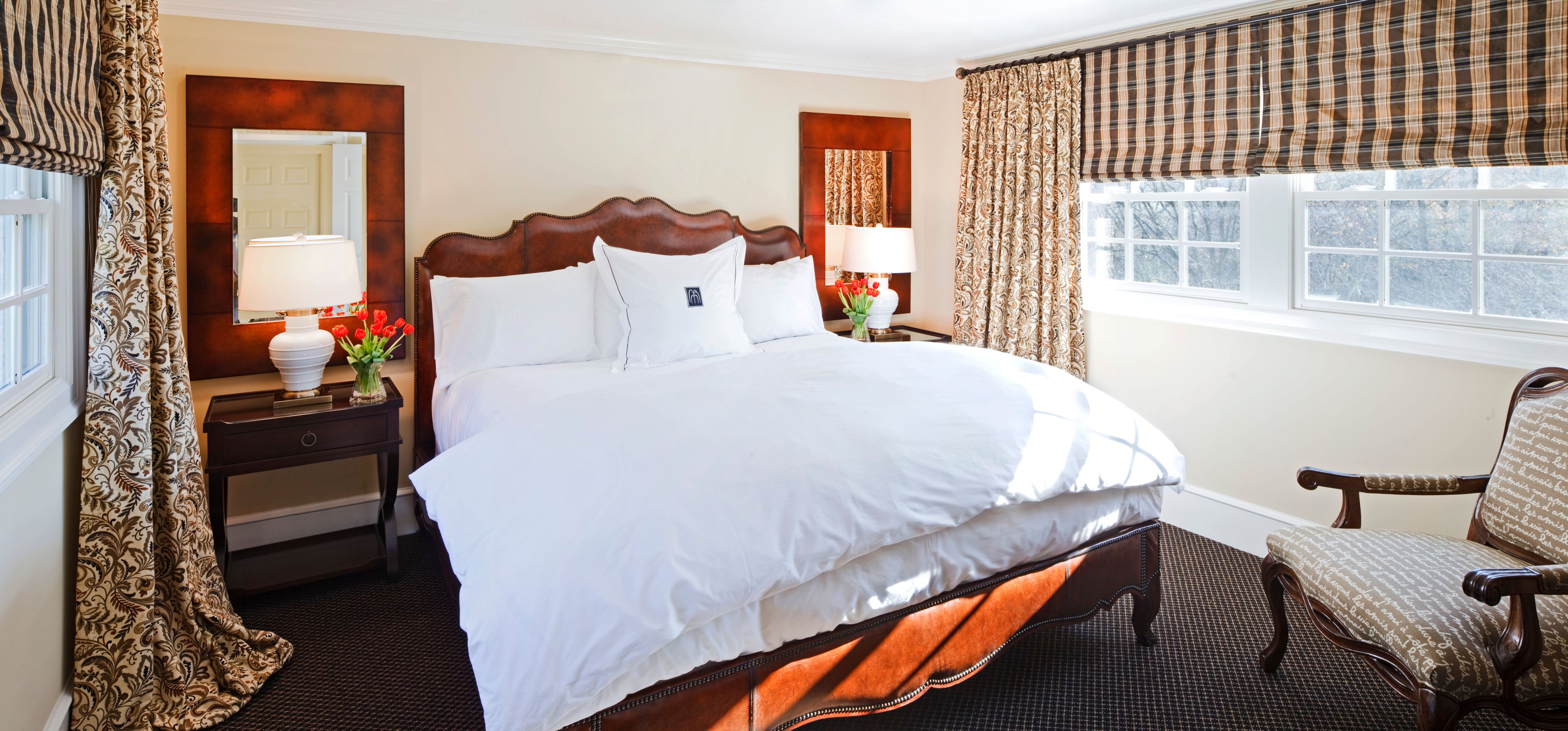 a bed with white sheets and pillows in a room