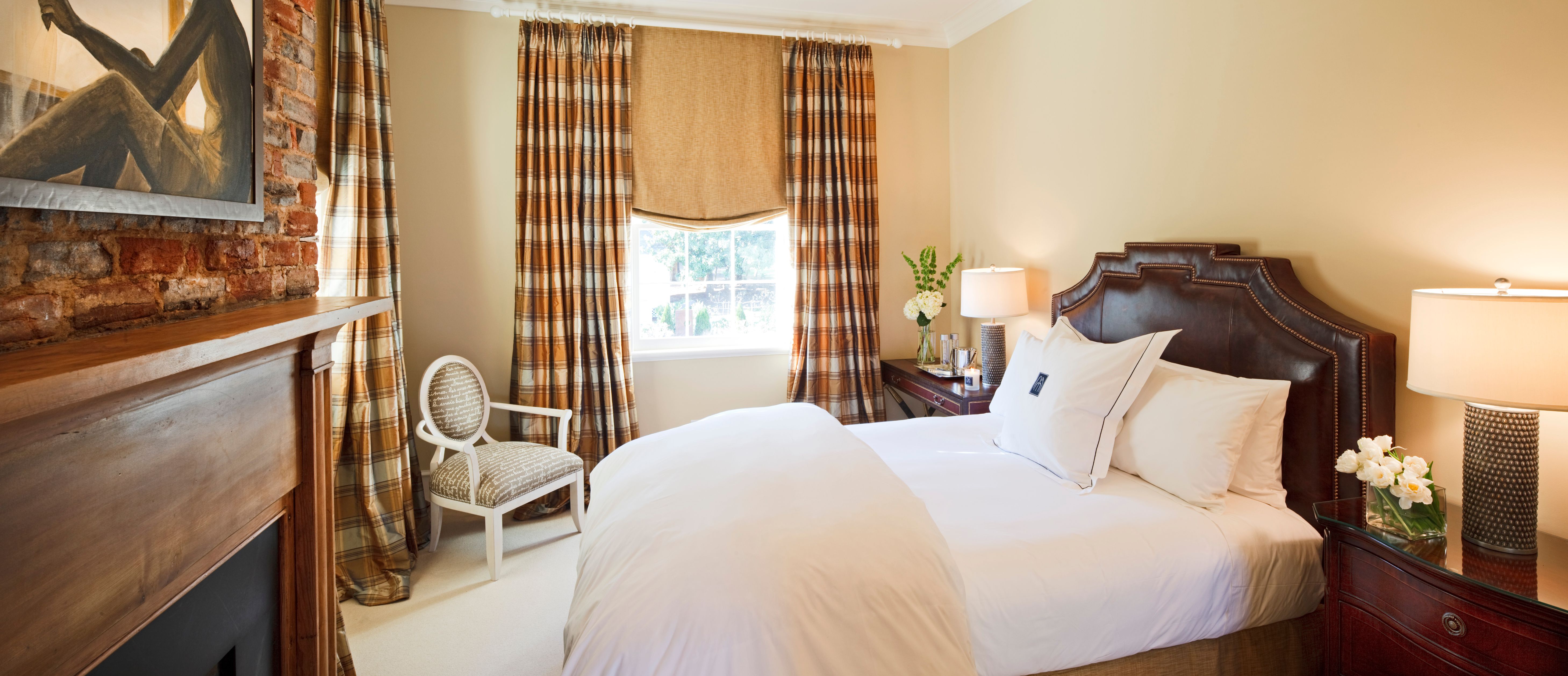 a bed with a lamp and a chair in a room