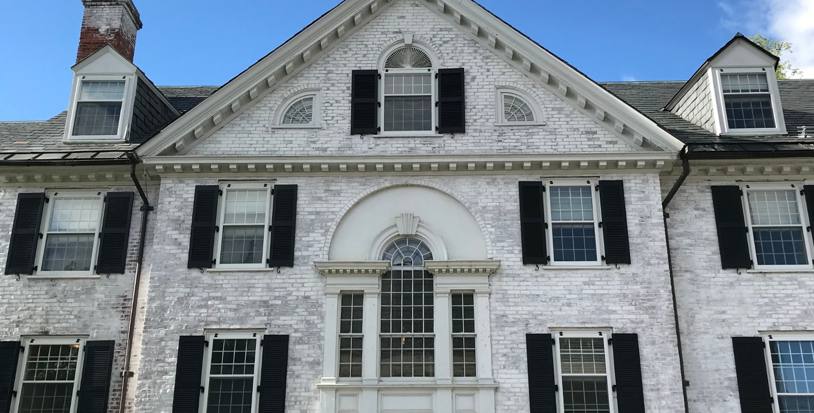a white brick house with black shutters