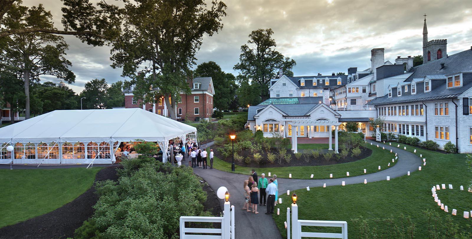 a group of people outside a white tent