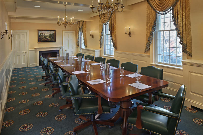 a long conference table with chairs and a chandelier