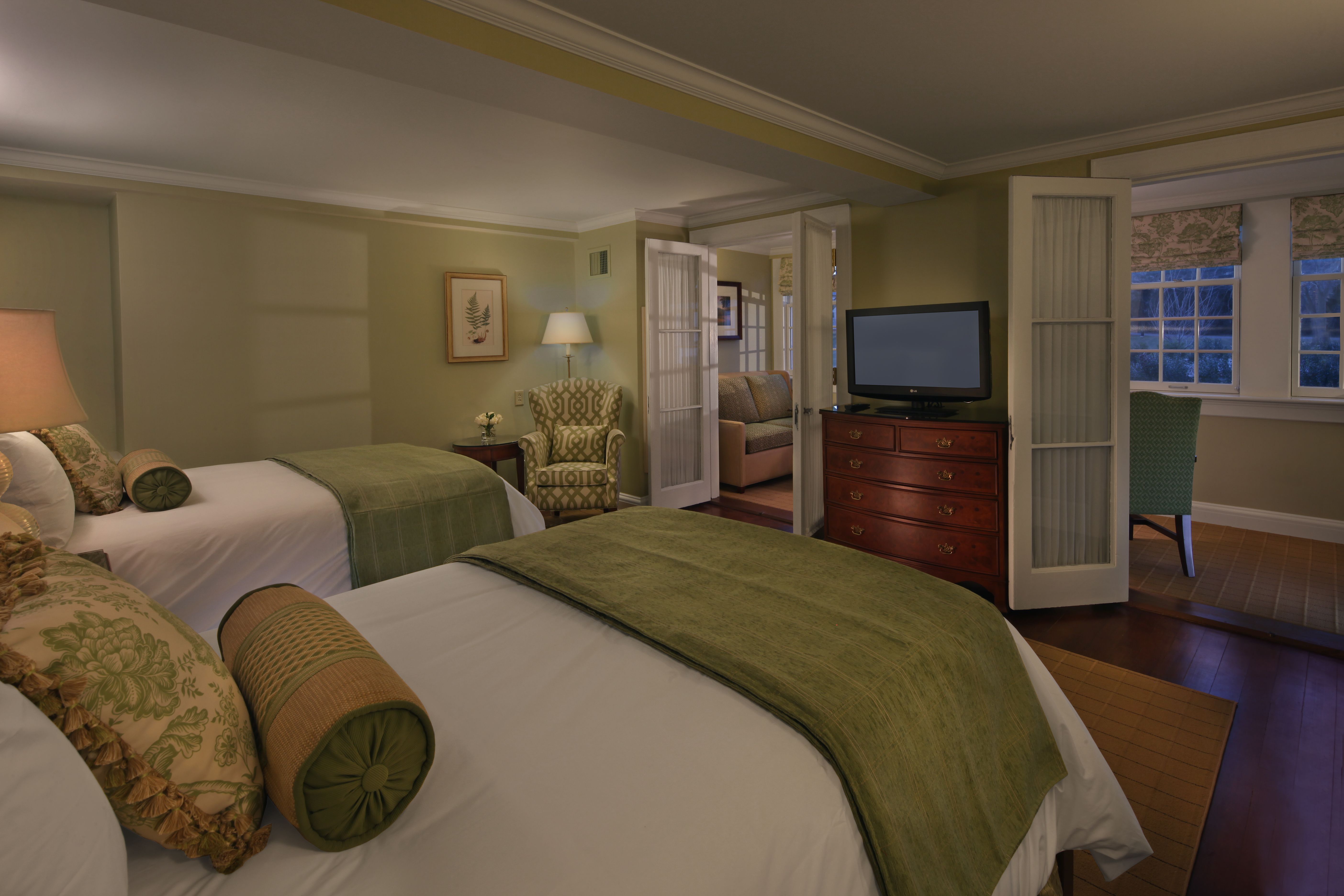 a bedroom with two beds and a television
