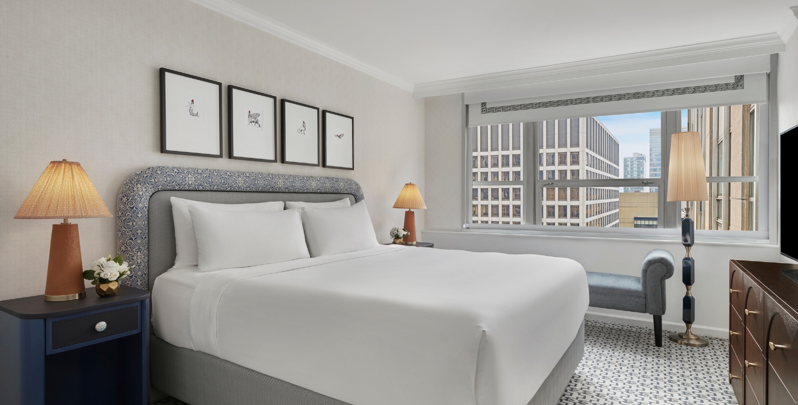 a bed with a lamp and pictures on the wall