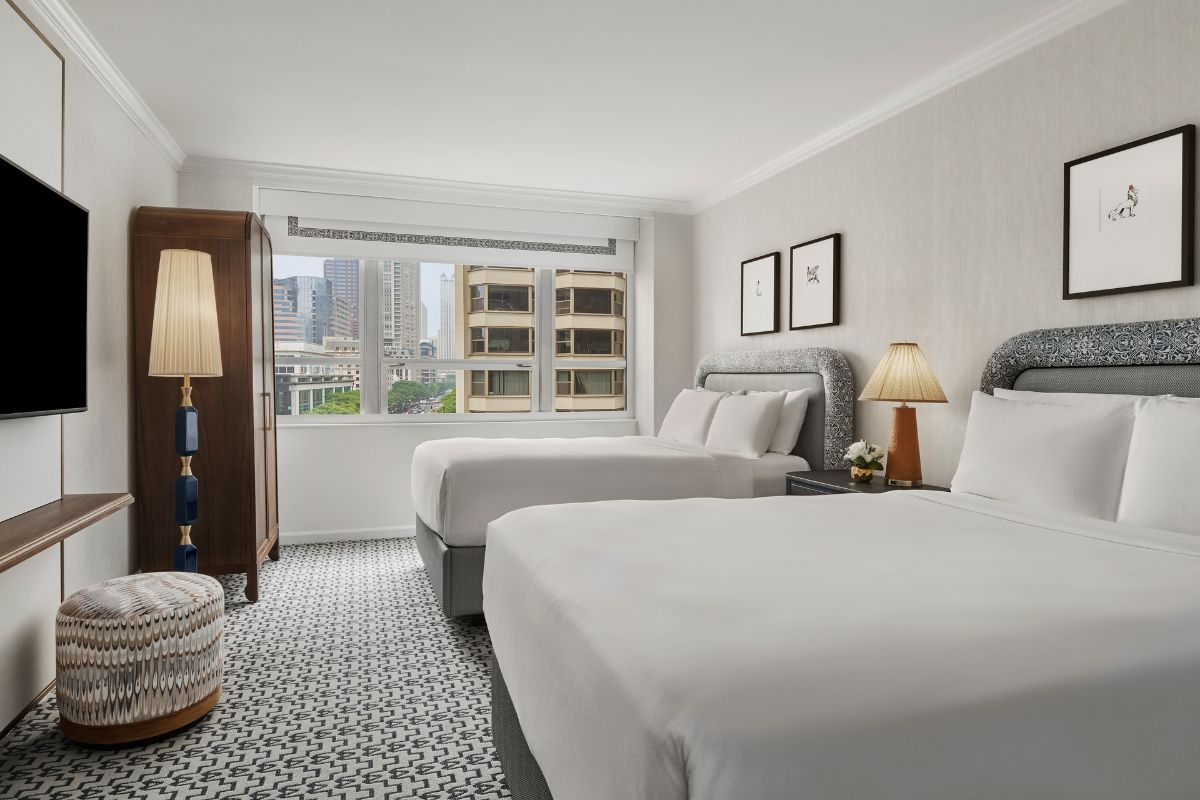 a room with two beds and a lamp