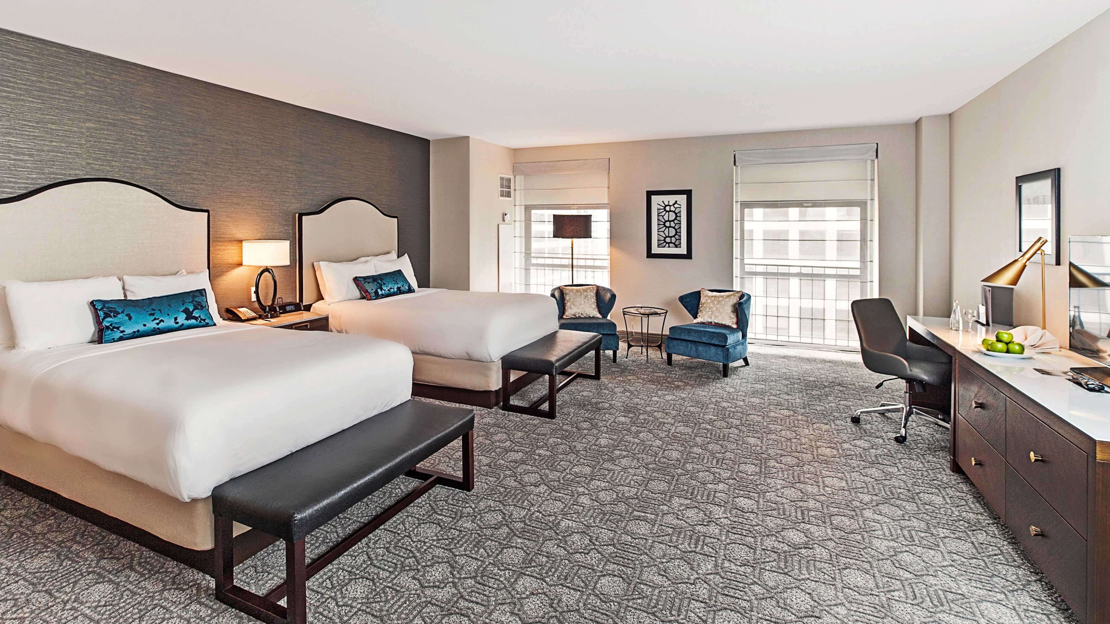 a room with two beds and a chair