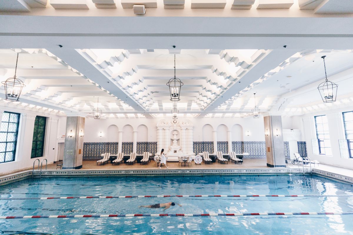 a swimming pool with chairs and a woman in it