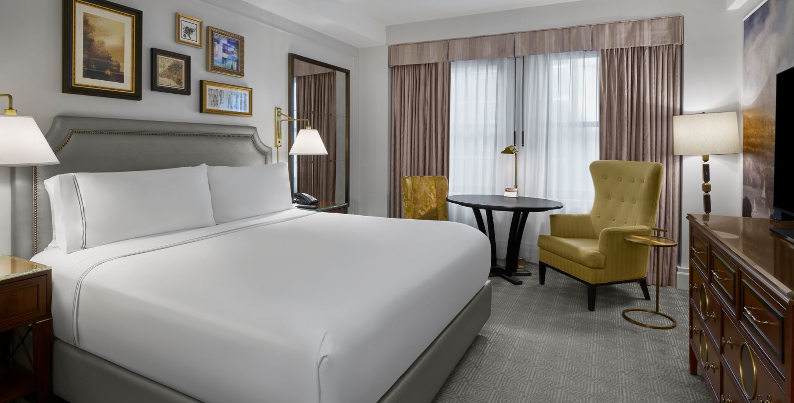 a room with a bed and a table and chairs