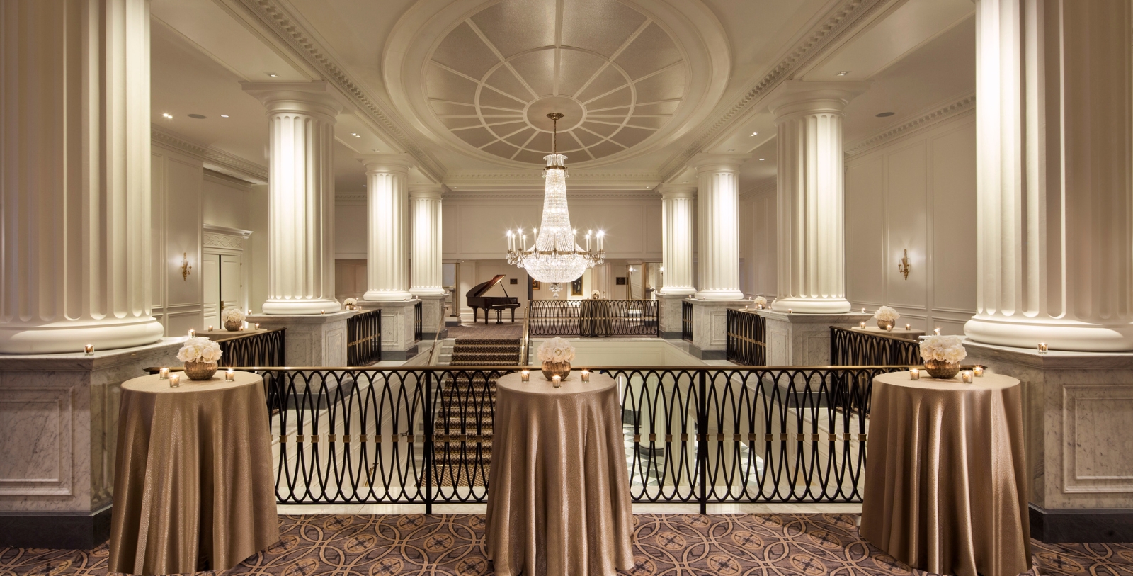 a table with a chandelier in a room with columns
