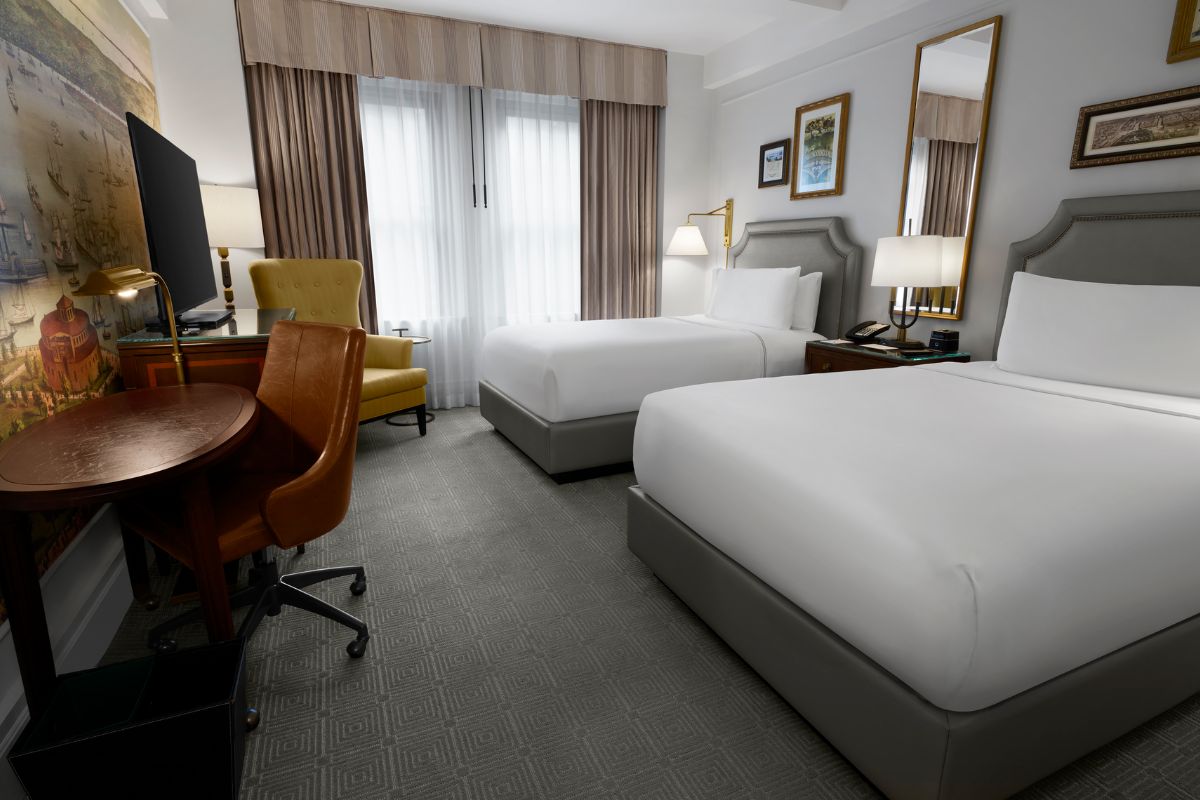 a room with two beds and a desk