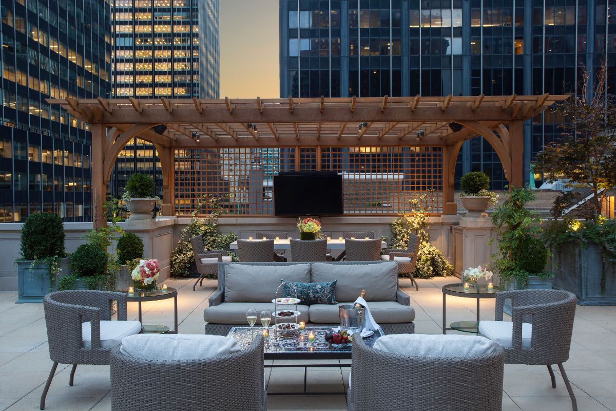a patio area with a pergola and chairs