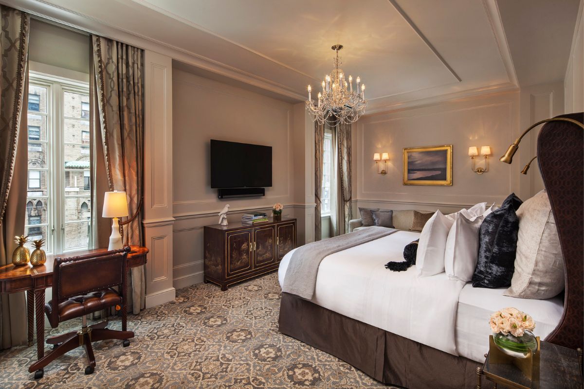 a bedroom with a bed and a chandelier