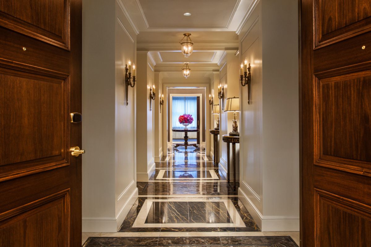 a hallway with marble floor and lamps