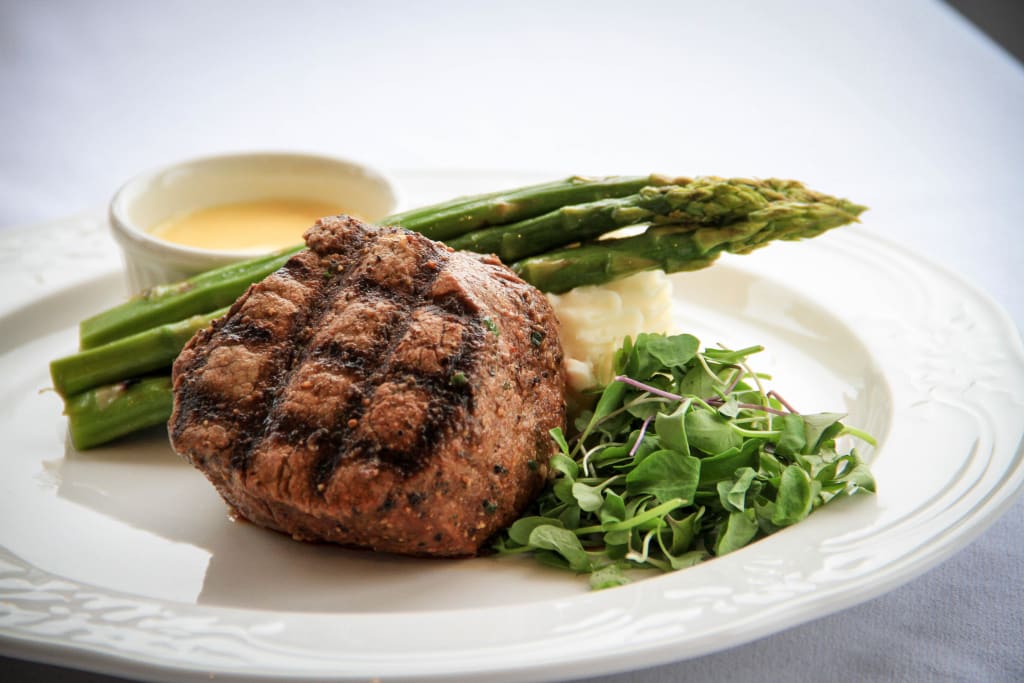 a plate of food with asparagus and mashed potatoes