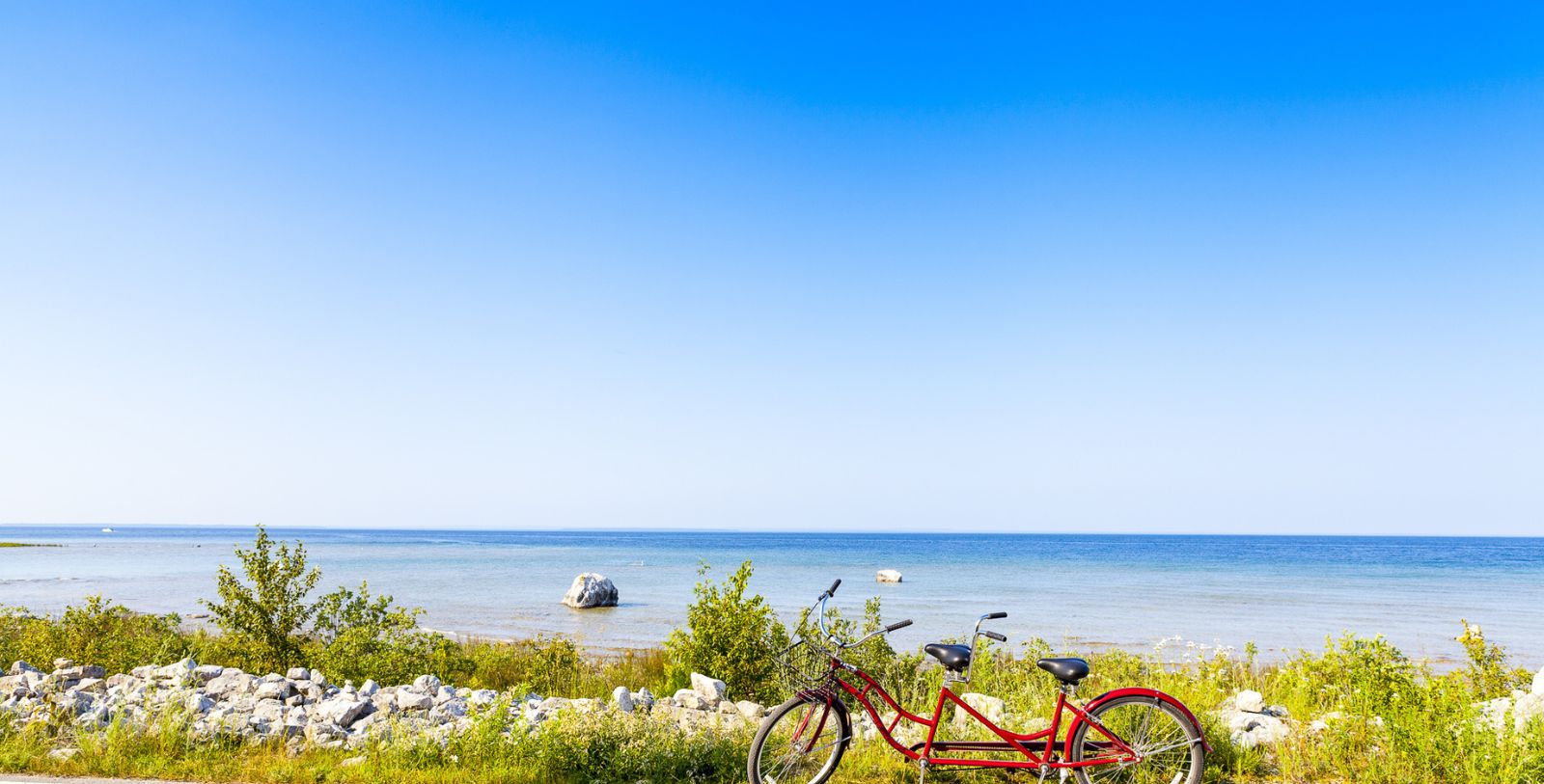 a red bicycle next to a body of water