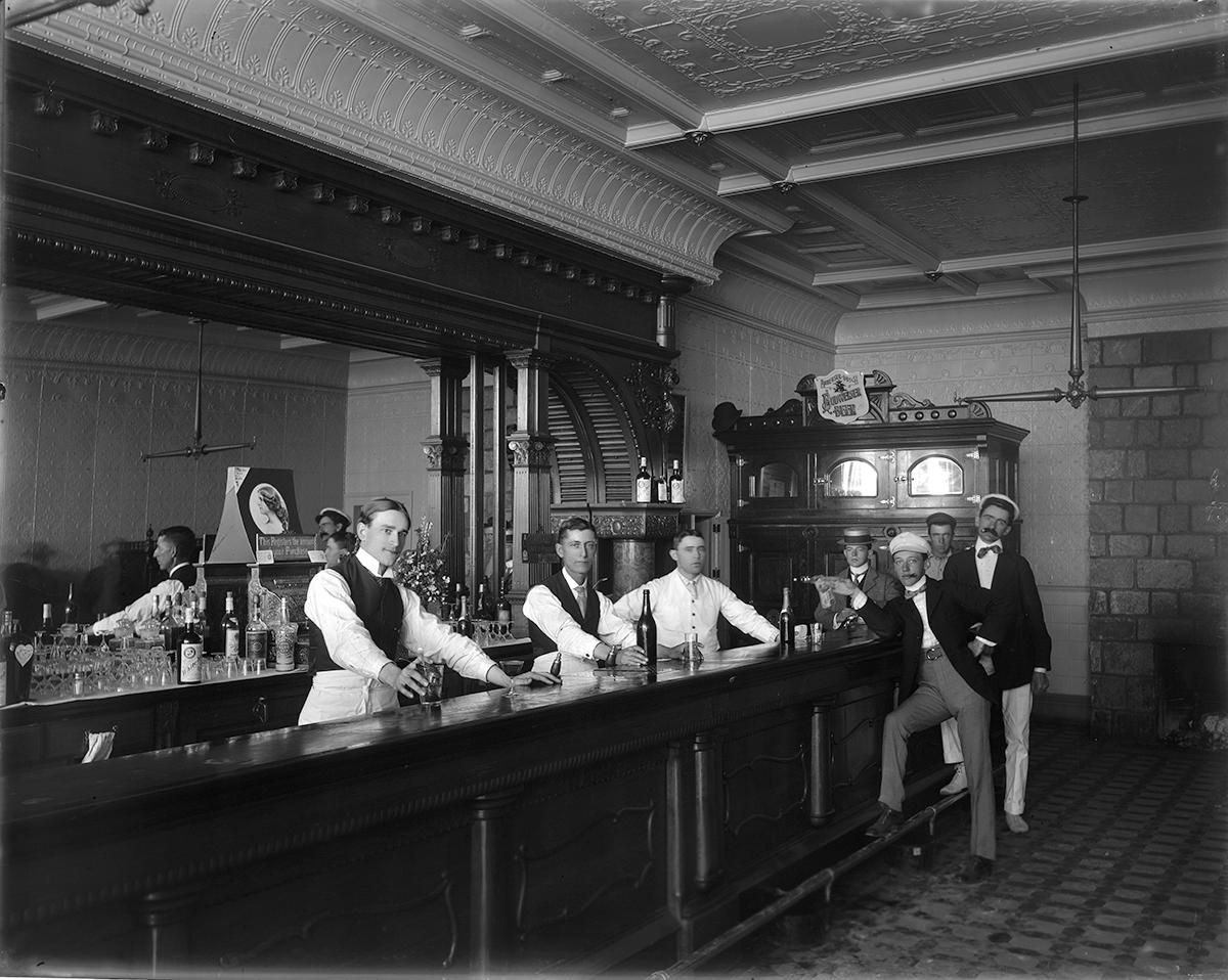 a group of men standing at a bar
