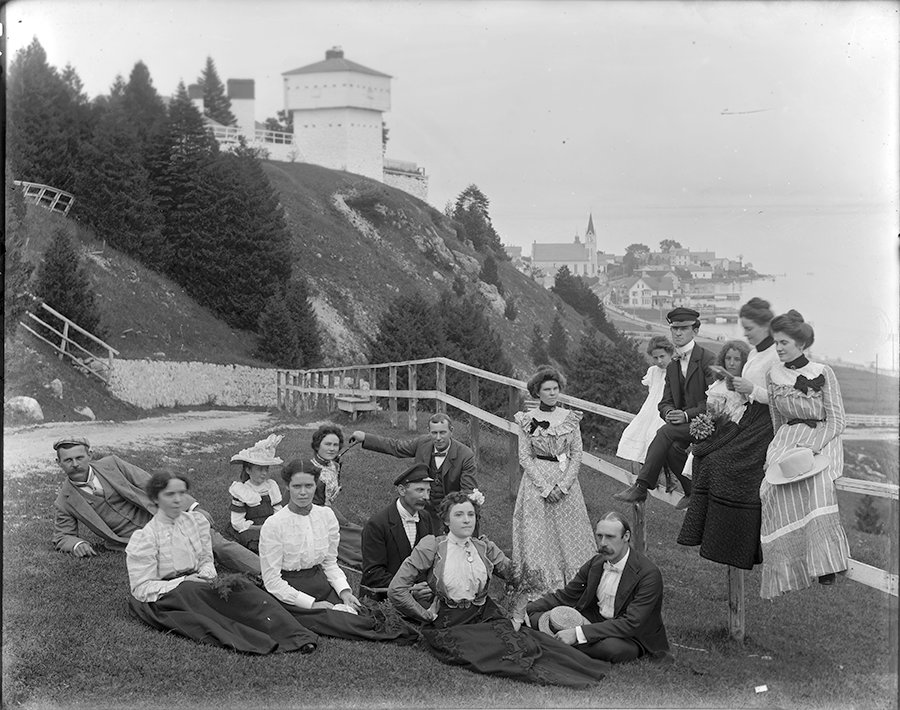 a group of people sitting on grass