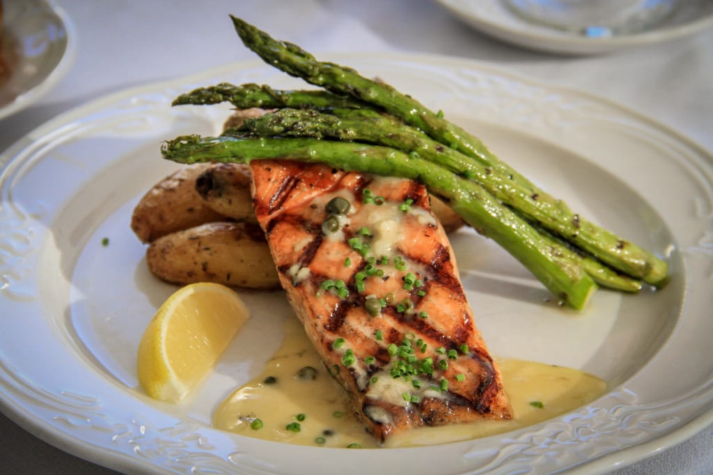 a plate of food with a lemon wedge and asparagus