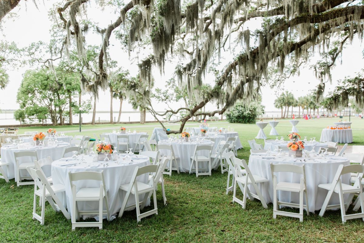 a group of tables and chairs under a tree