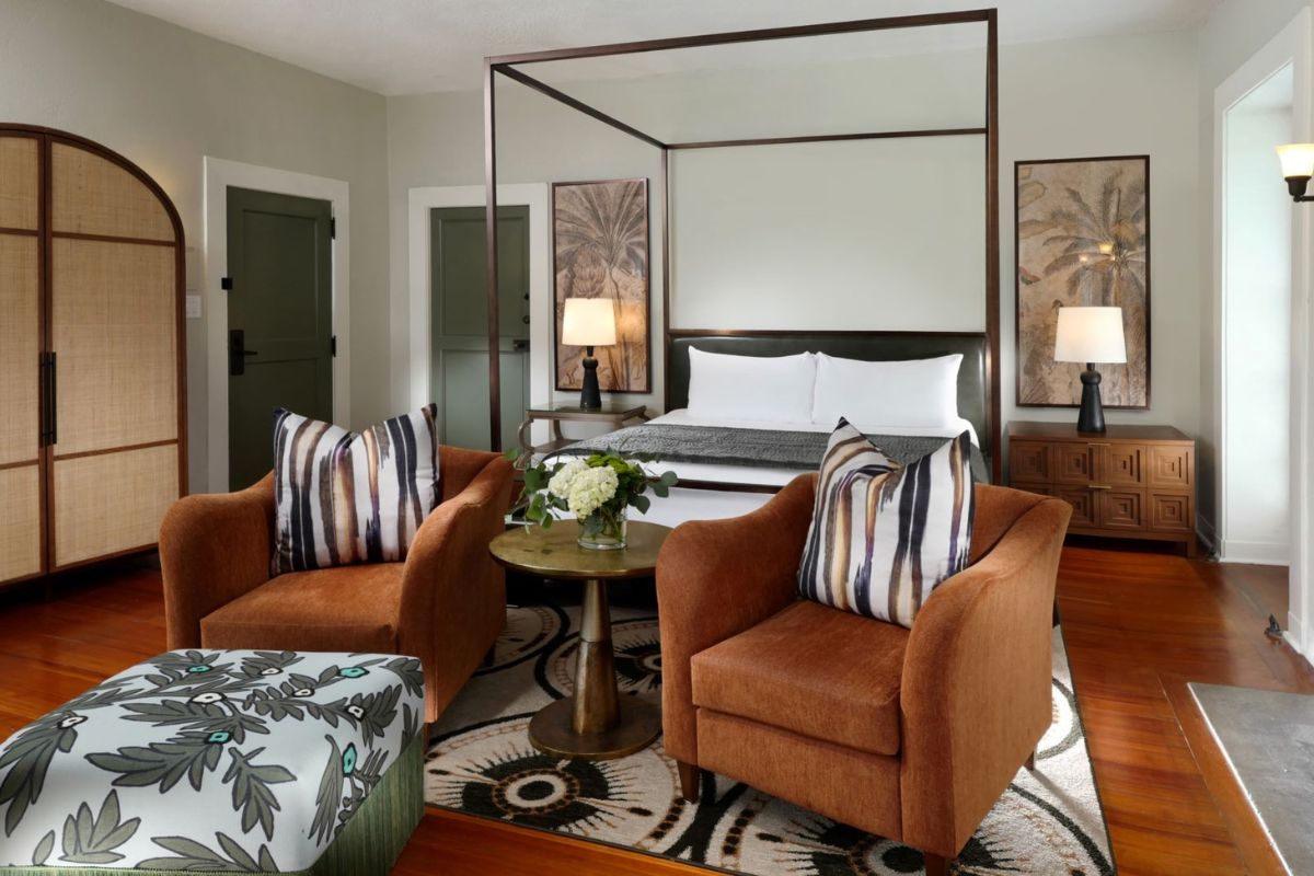 a bedroom with a bed and chairs