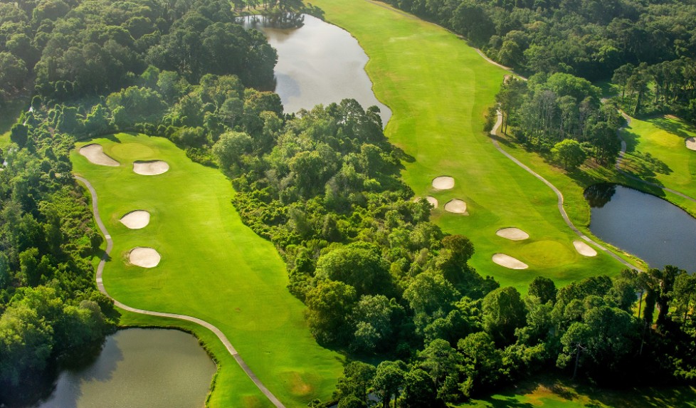 a golf course with water and trees