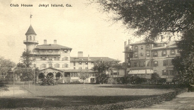 a large building with a lawn and trees