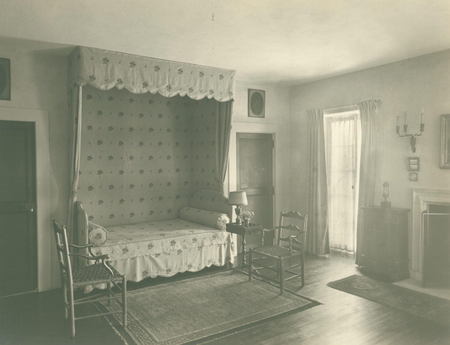 a room with a bed and chairs