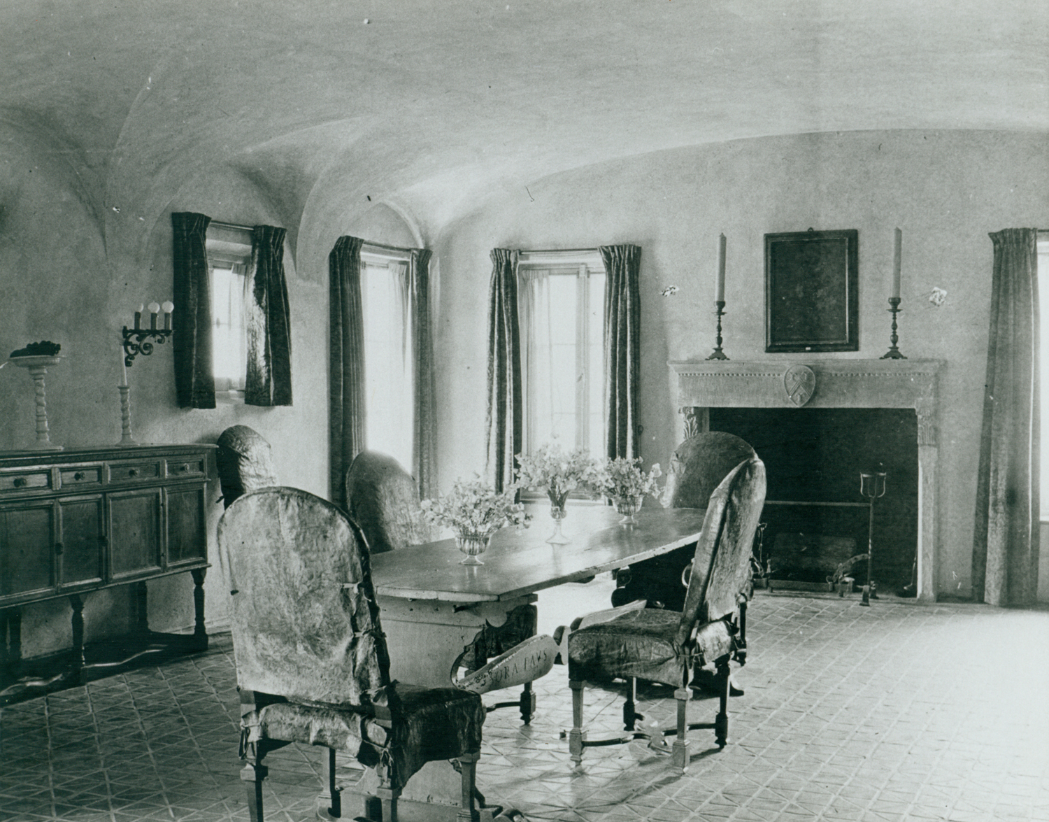 a dining room with a fireplace and chairs