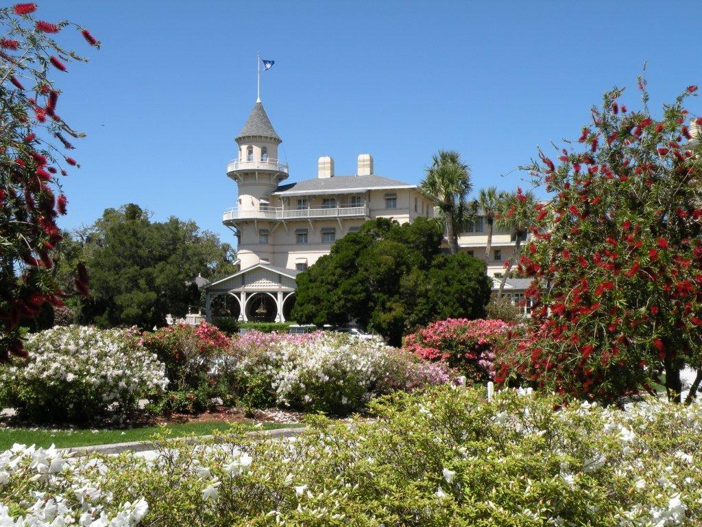 a large white building with a tower and a garden