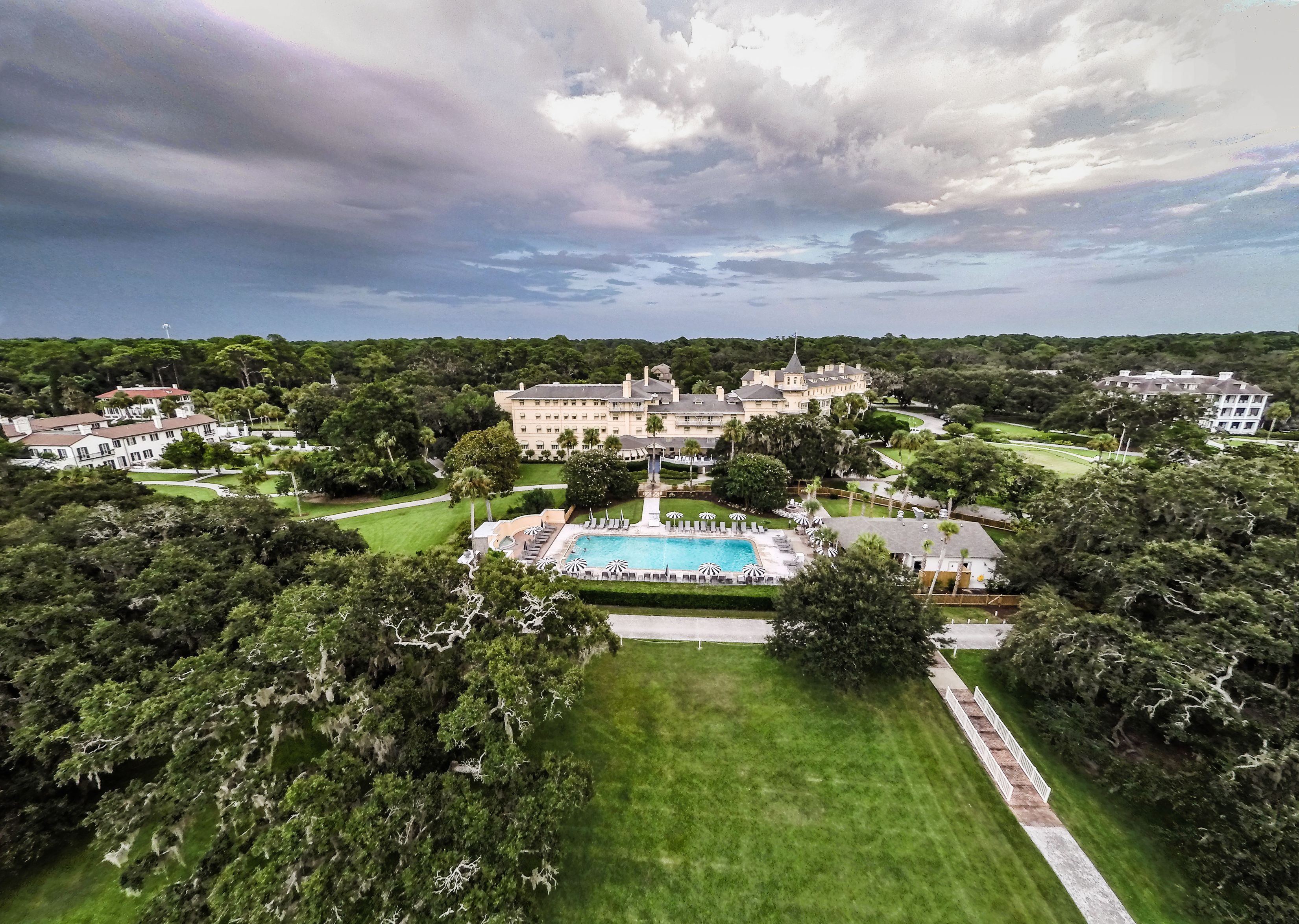 a large building with a pool and trees