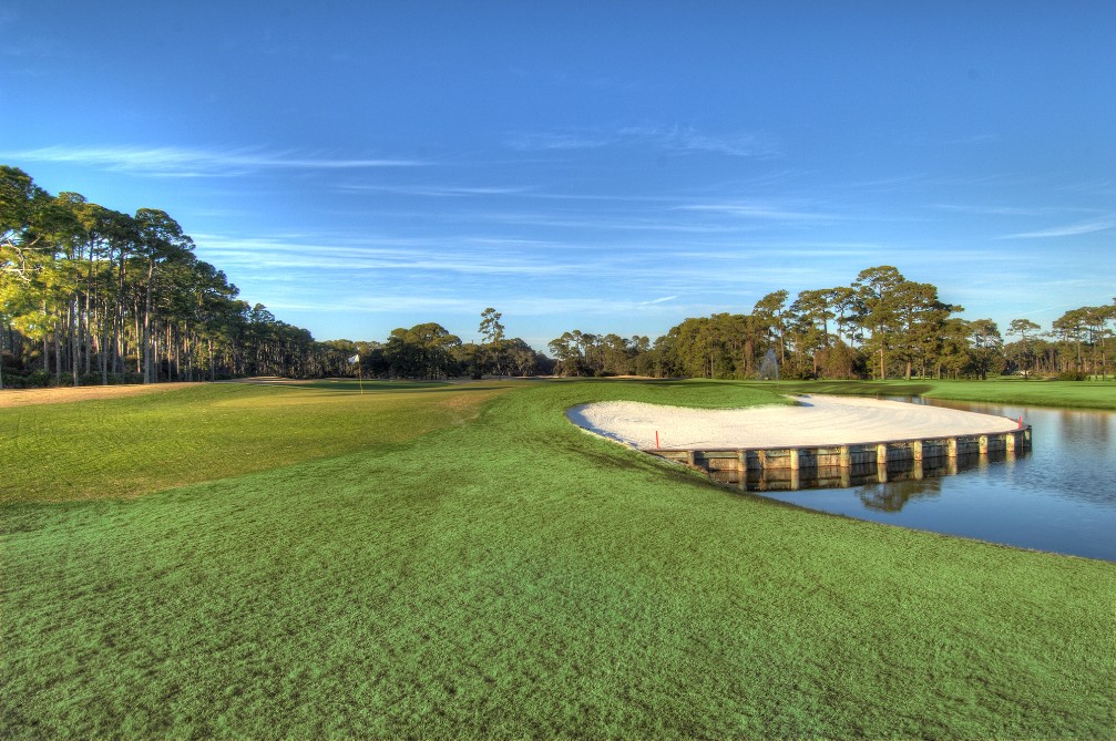 a golf course with a pond and sand trap