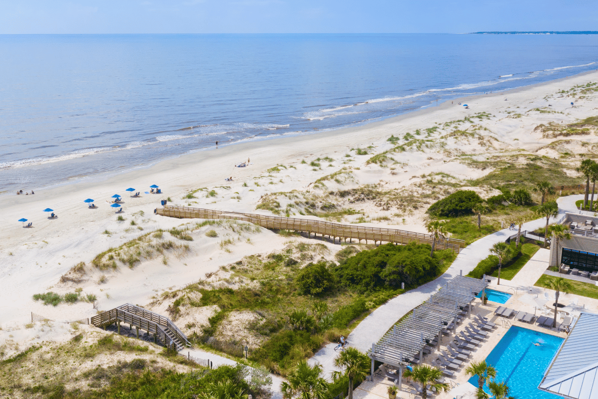 a beach with a swimming pool and a walkway