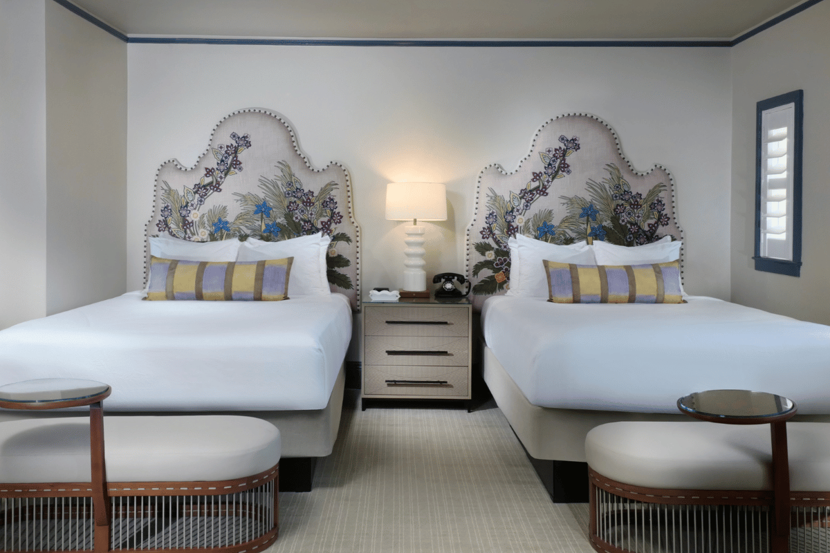 a room with two beds and a lamp