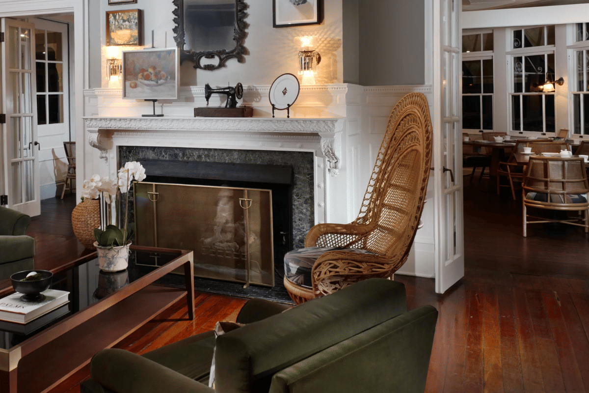 a room with a fireplace and a wicker chair