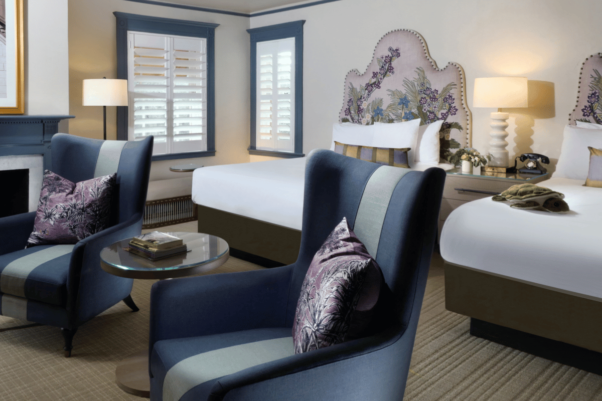 a room with a bed and chairs