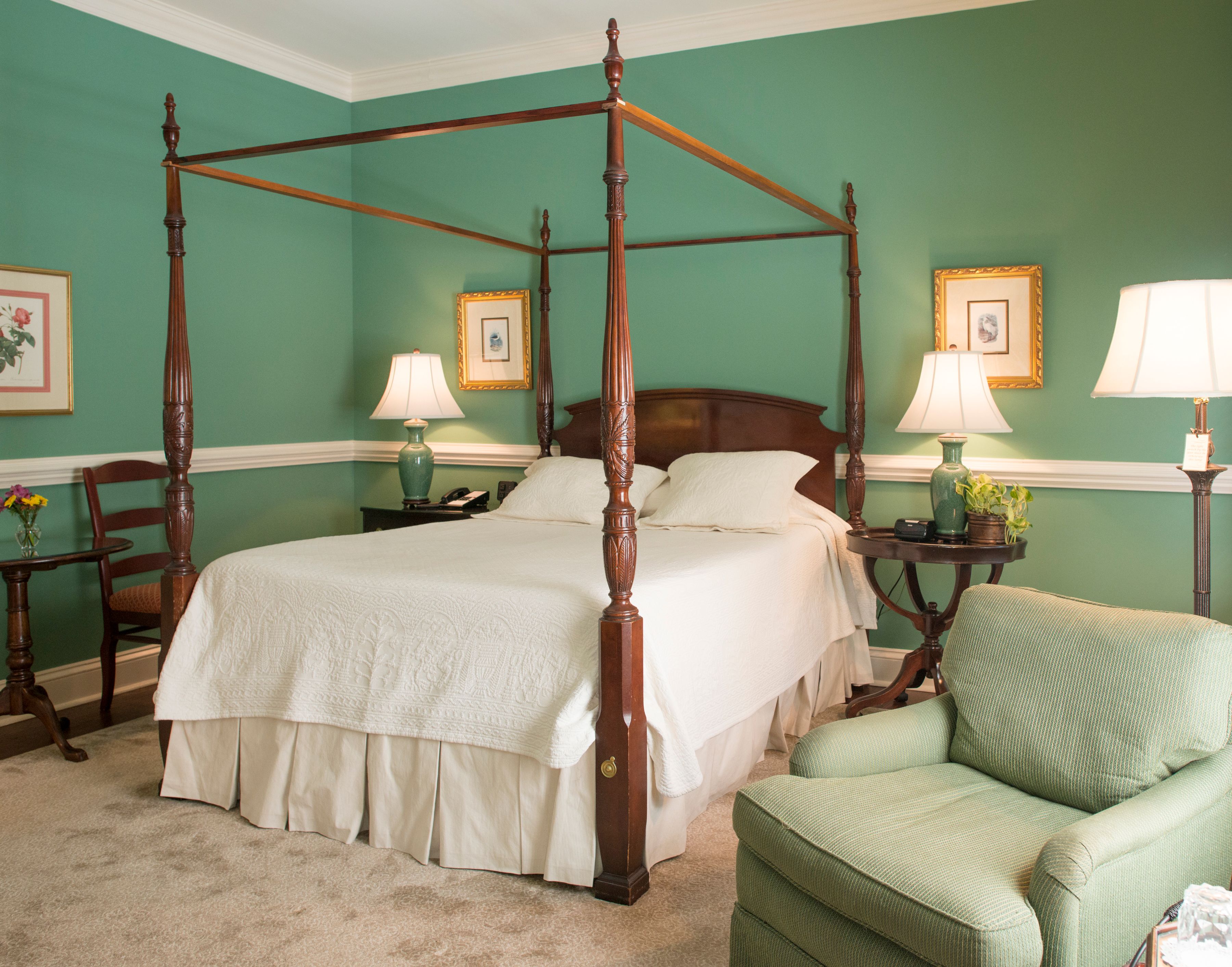 a bedroom with a four poster bed and a chair