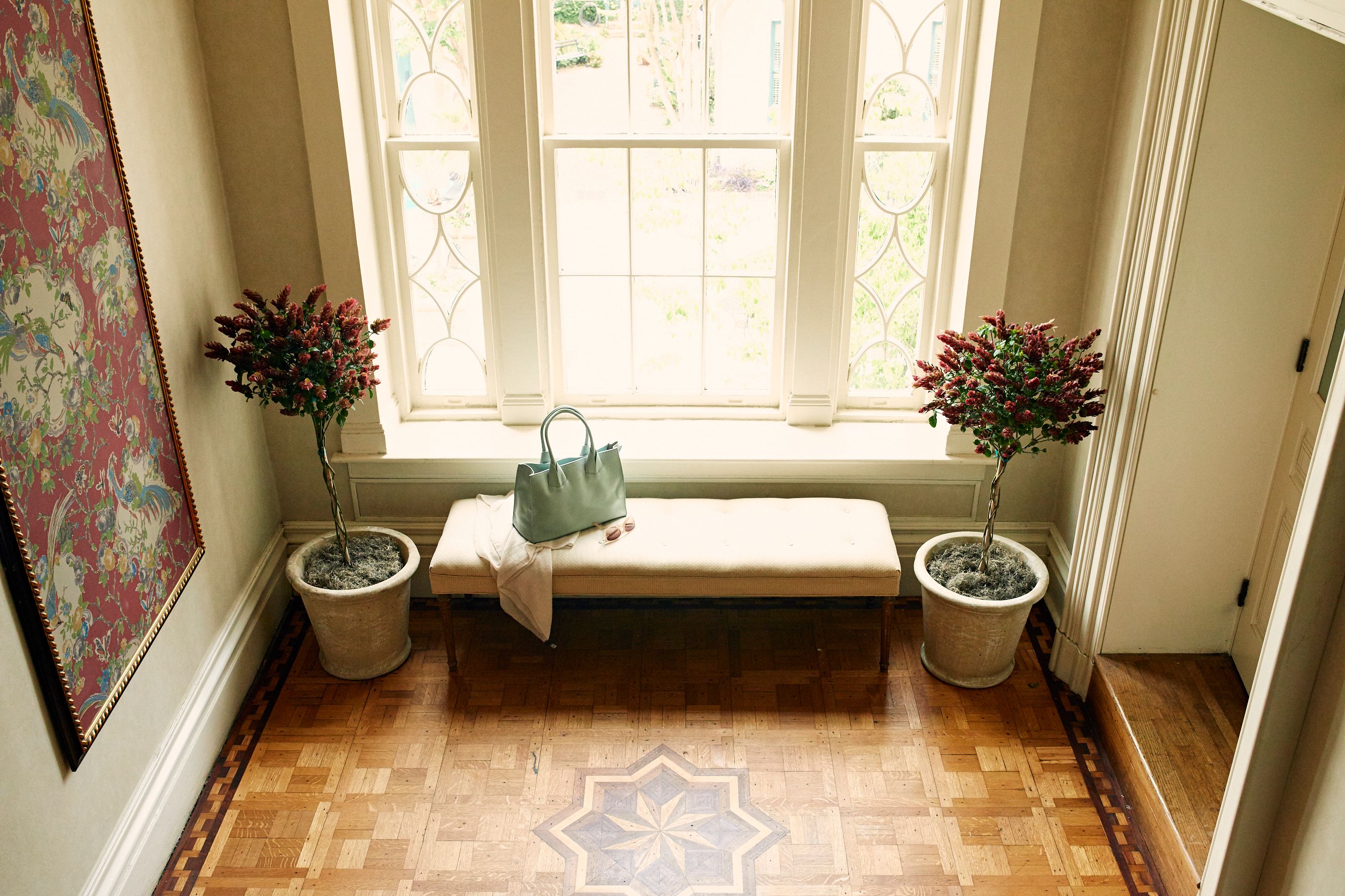 a bench with flowers in front of a window