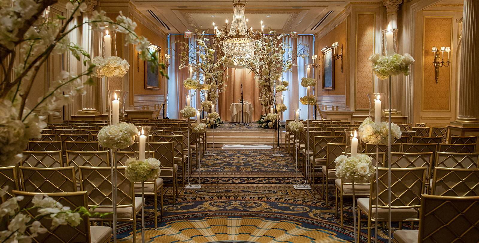 a wedding ceremony with chandeliers and flowers