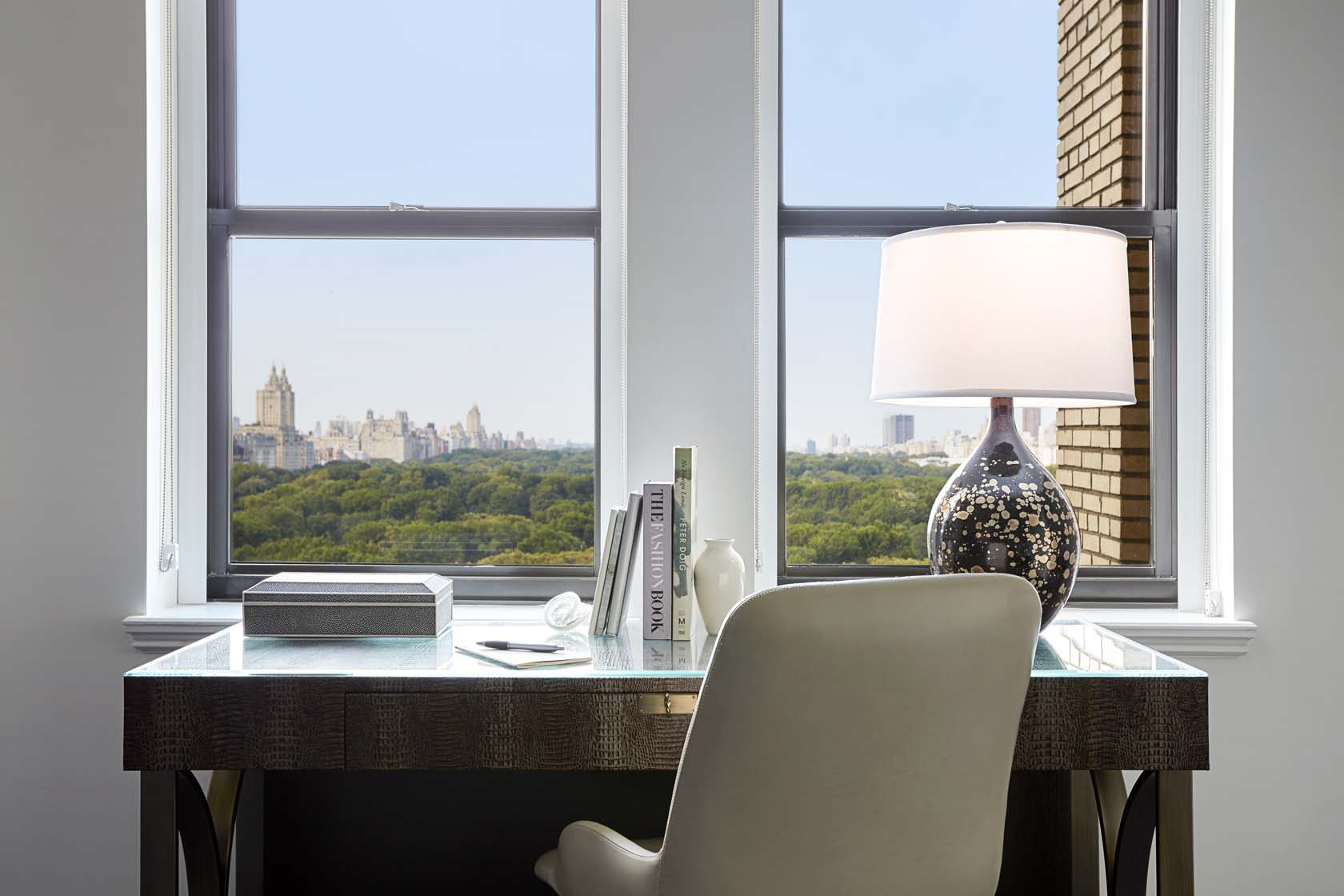 a desk with a lamp and a window