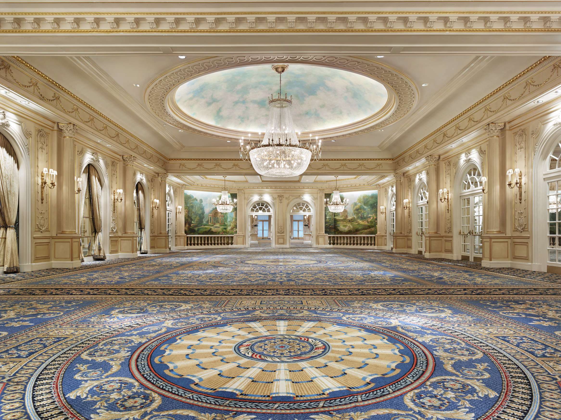 a large room with a chandelier and a round carpet